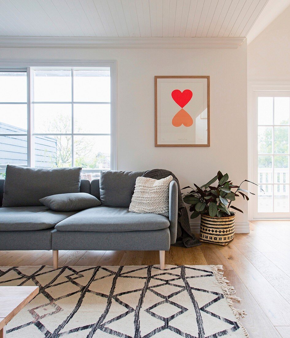 Graphically patterned carpet in front of a gray sofa