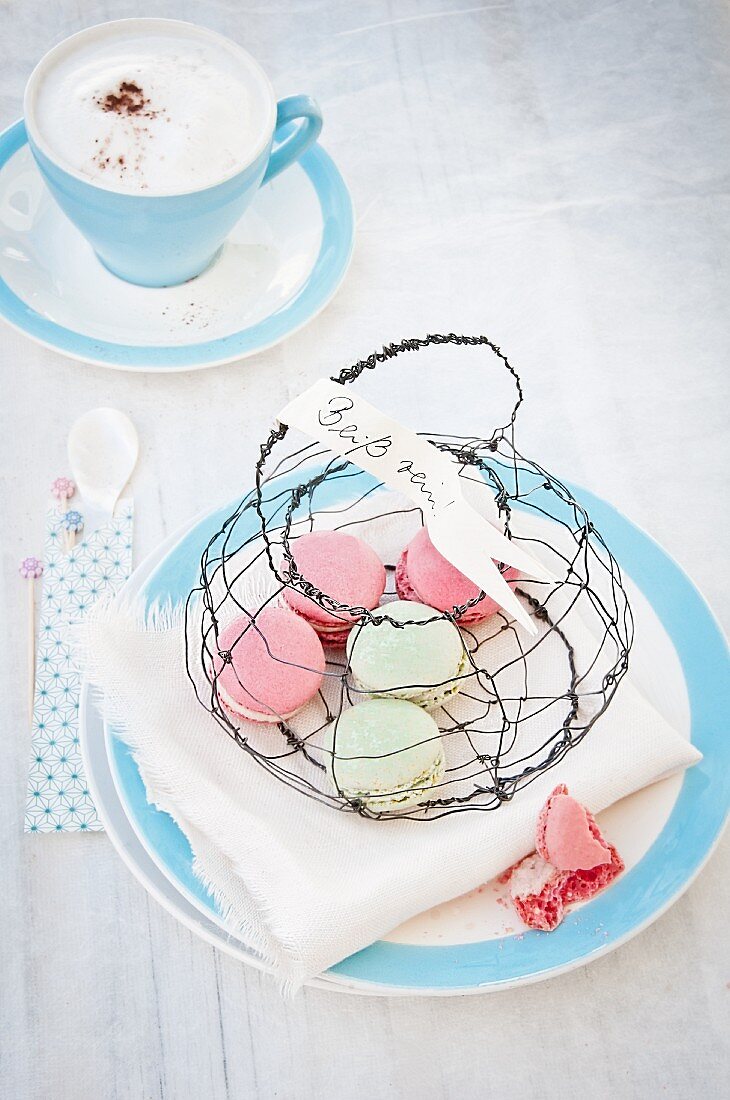 Macarons in hand-made wire basket and cup of cappuccino