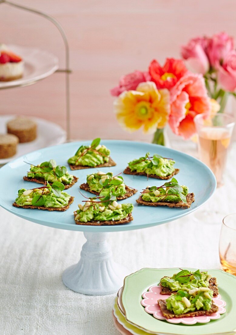 Zucchini crackers with avocado, micro greens and pine nuts