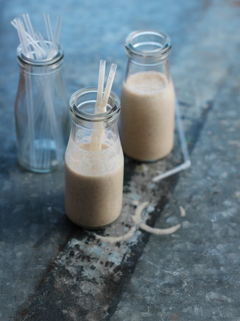 Nutty milkshake in small glass bottles with straws