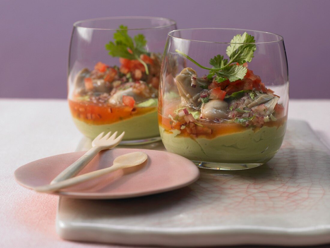 Marinated oysters on avocado cream with diced tomatoes