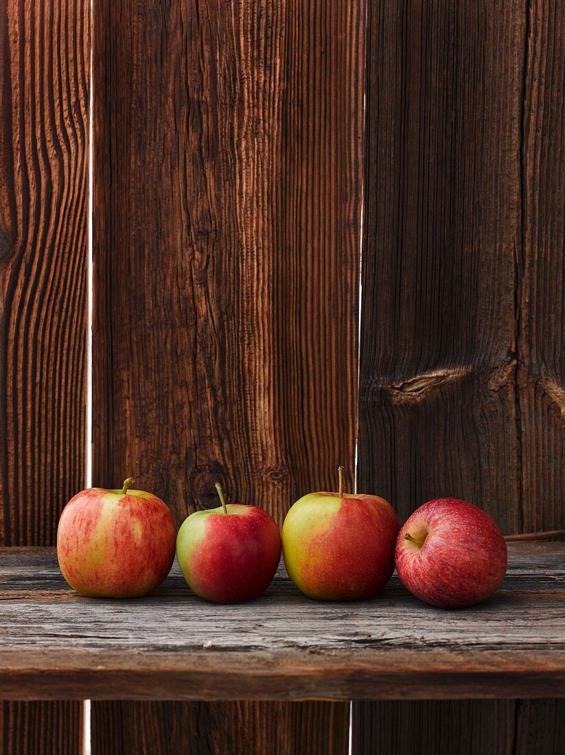 A row of fresh apples on a wooden table