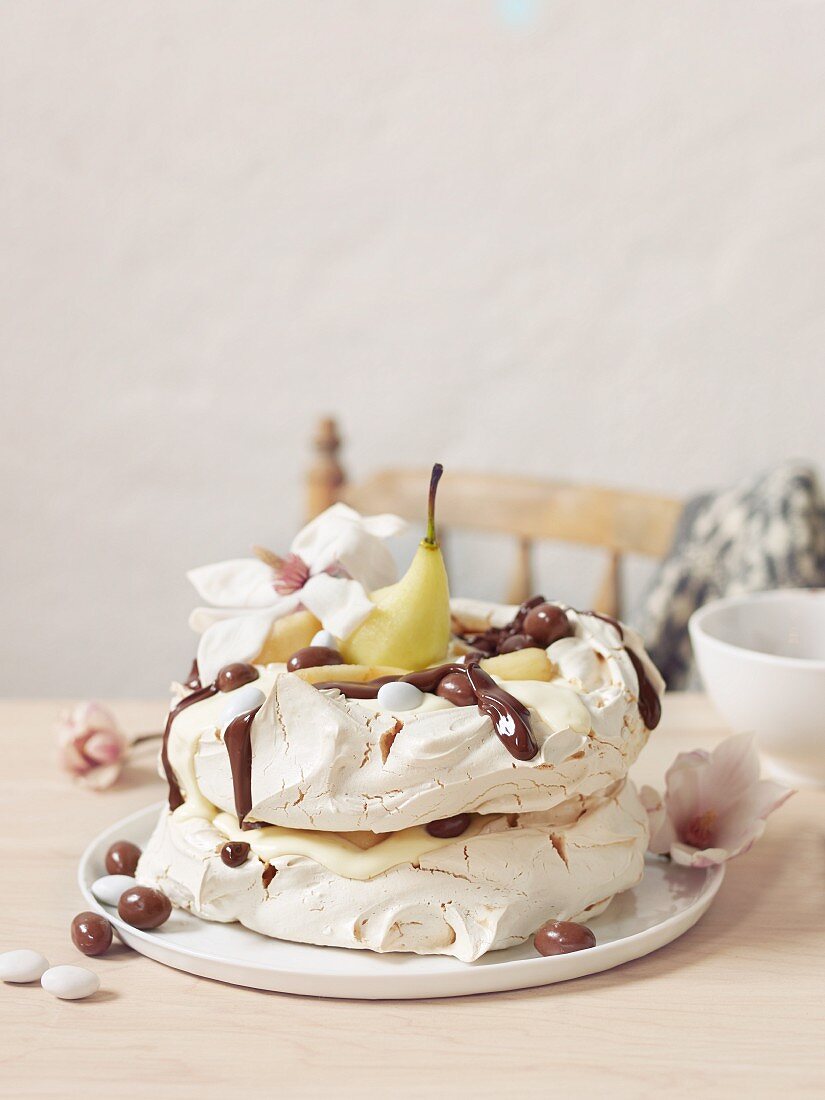 A meringue cake with pears and chocolate sauce