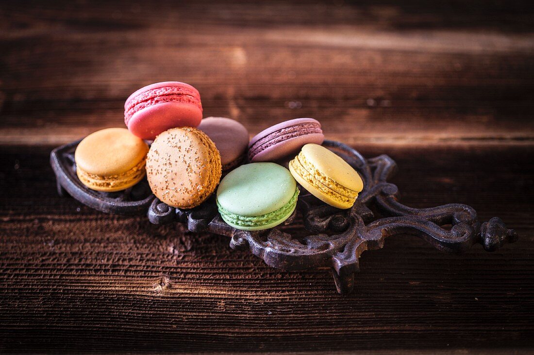 Colourful macarons arranged on a cast iron trivet