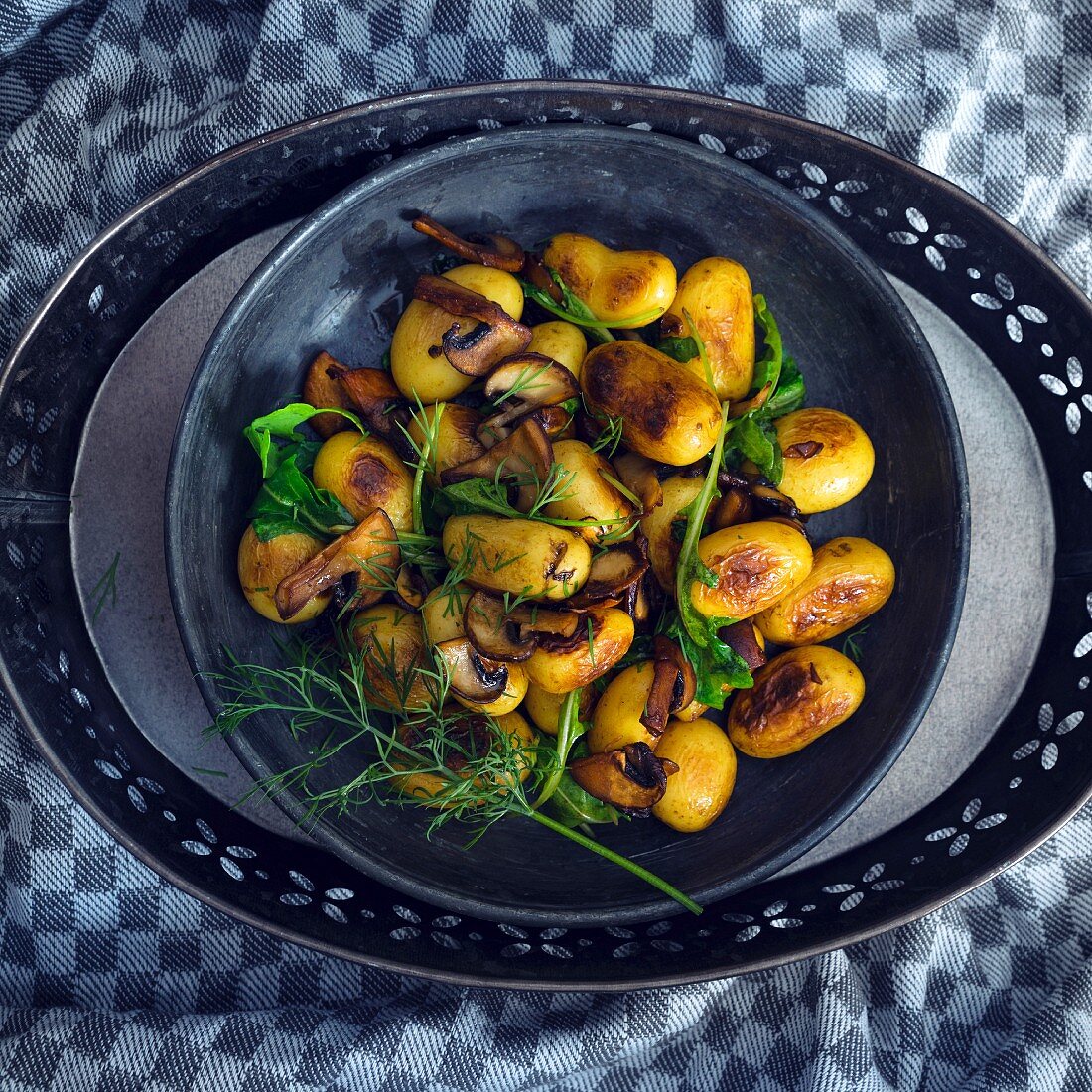 Vegan fried potatoes with mushrooms, rocket and dill