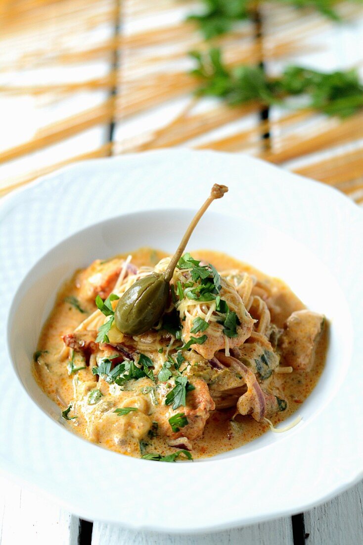 Chicken curry with noodles and giant capers