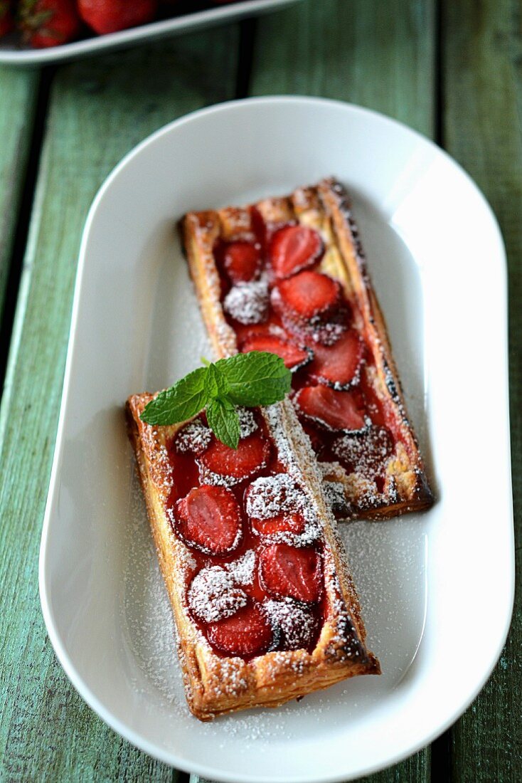 Puff pastry slices with strawberries and dusted with icing sugar