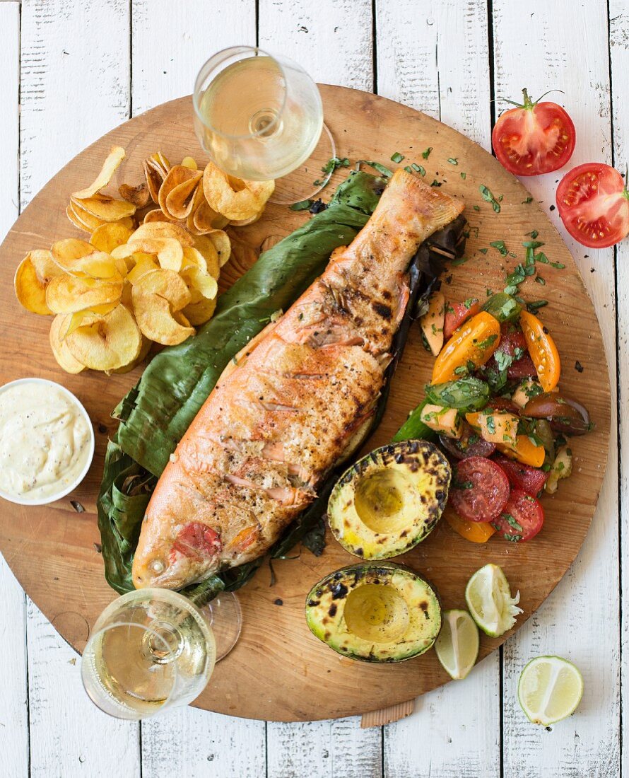 Grilled rainbow trout with avocado, tomato salad and potato crisps