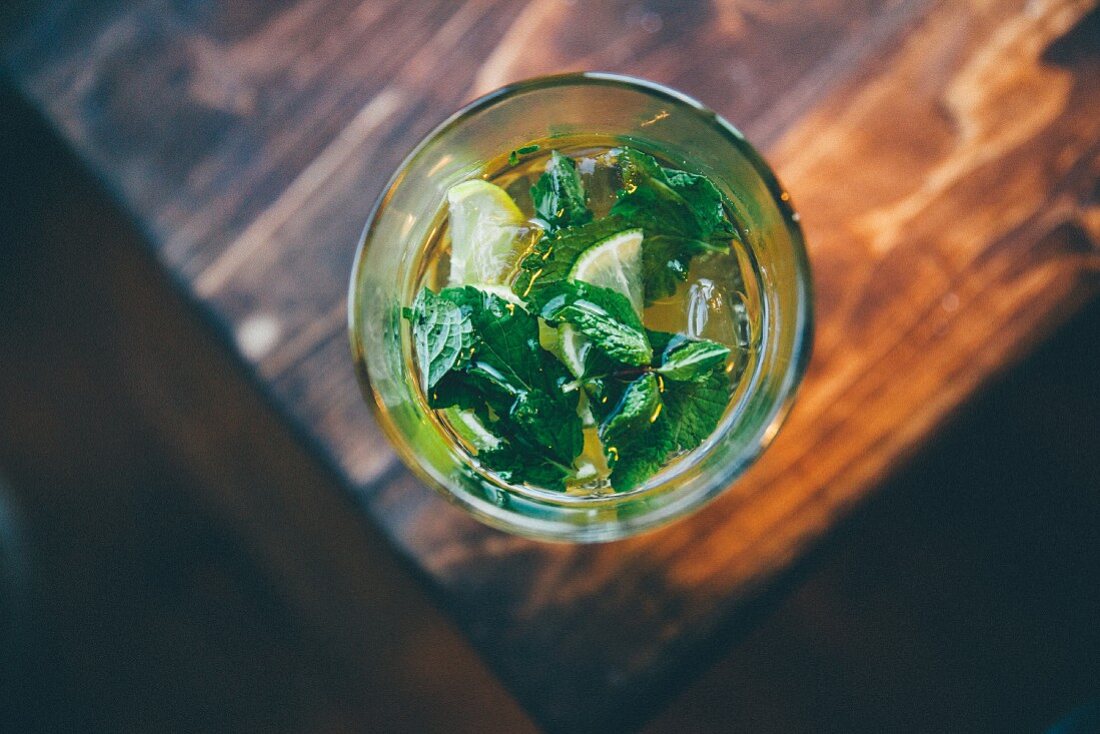 A cocktail with lemon slices and fresh mint