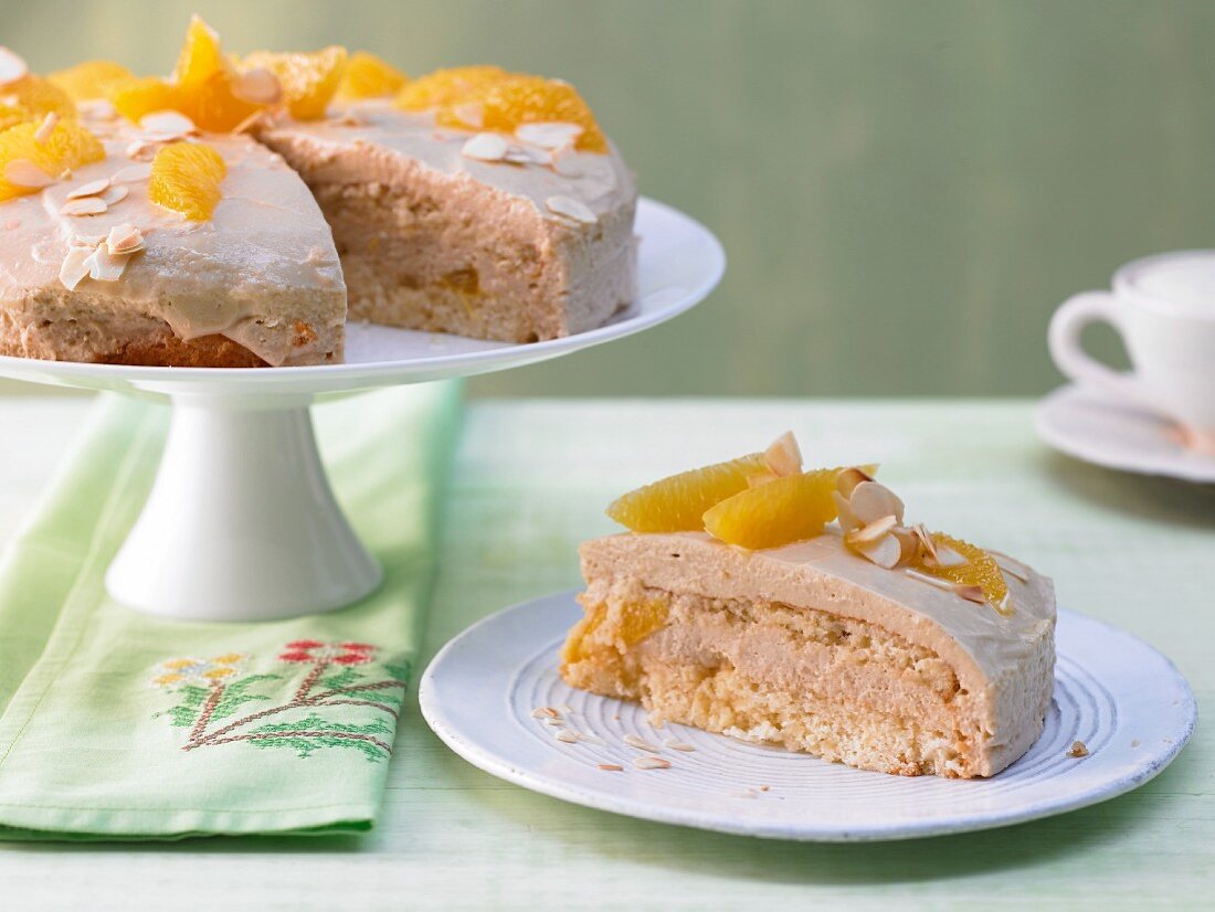 A caramel cream cake with orange segments and almonds