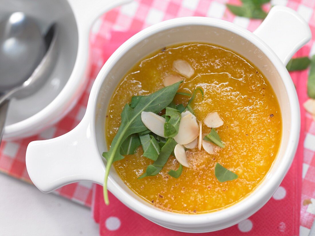 Carrot and potato cream soup with rocket and almond flakes