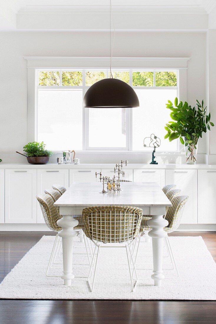 Bright dining room with white furniture and black light