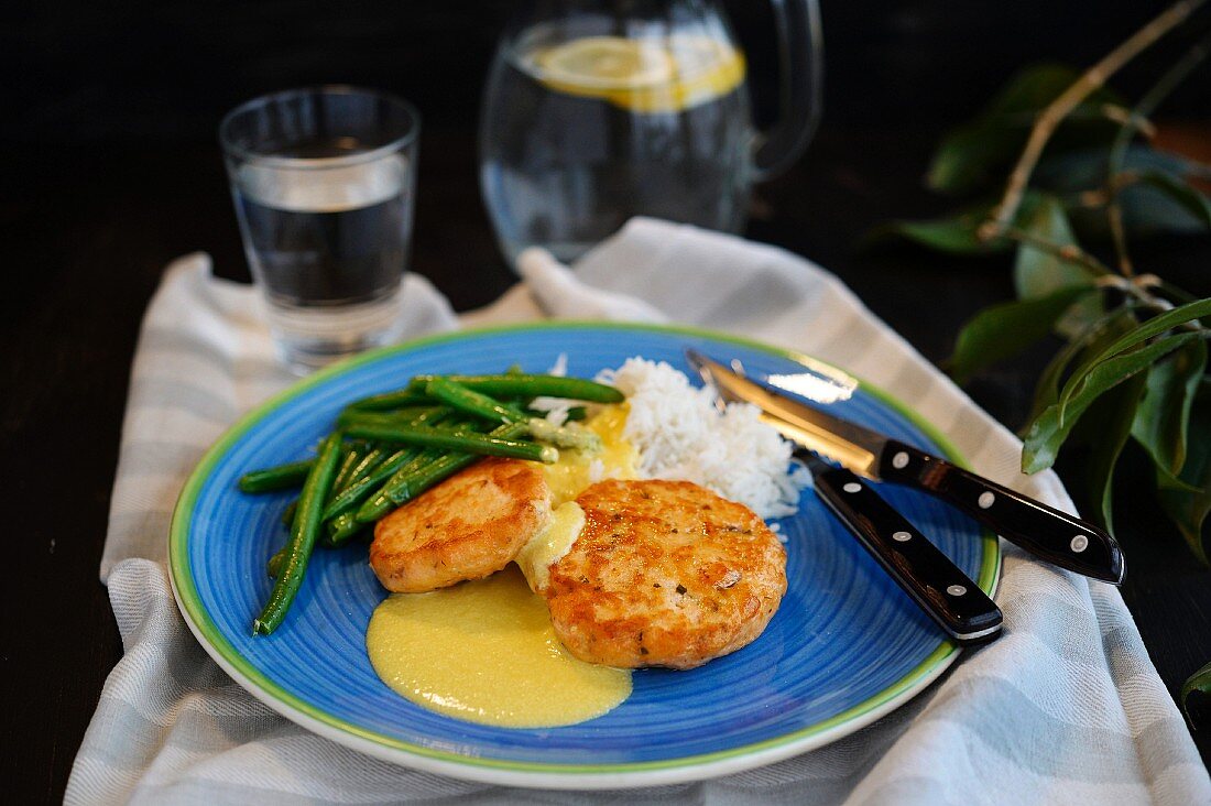 Lachsfrikadellen mit weißem Reis, Sauce Hollandaise und grünen Bohnen