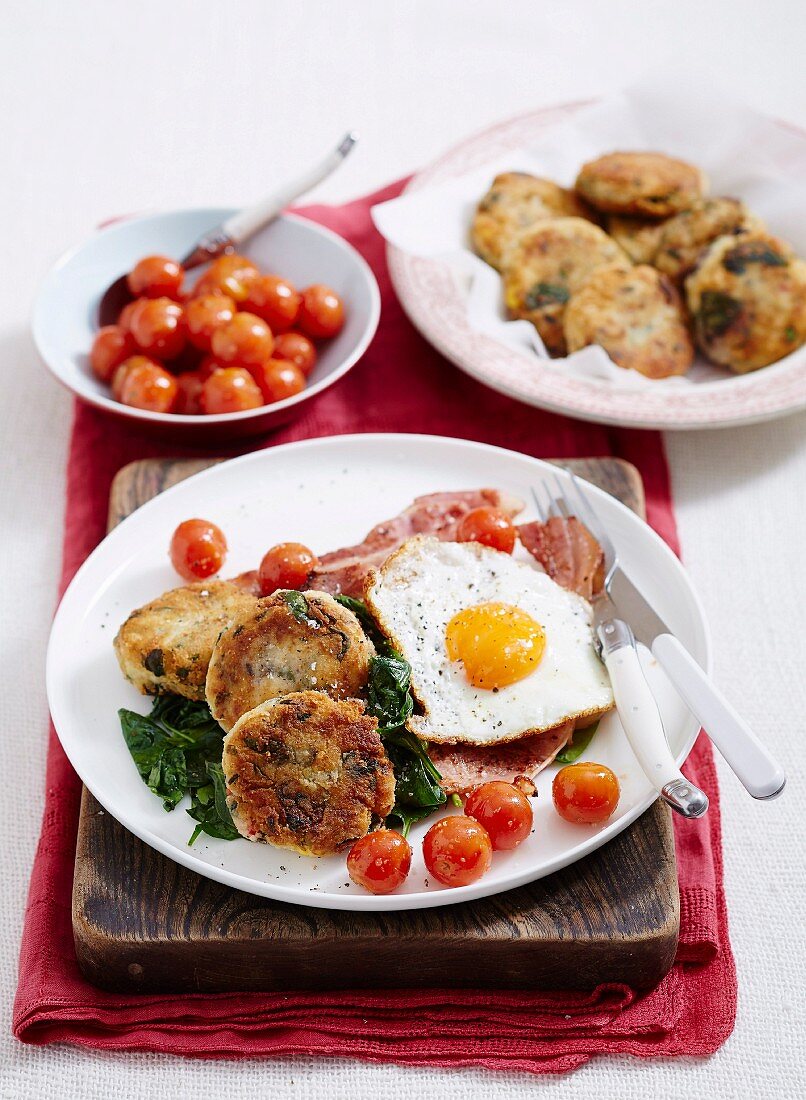 Käse-Gemüse-Frikadellen auf Spinat mit Bacon, Spiegelei und Kirschtomaten