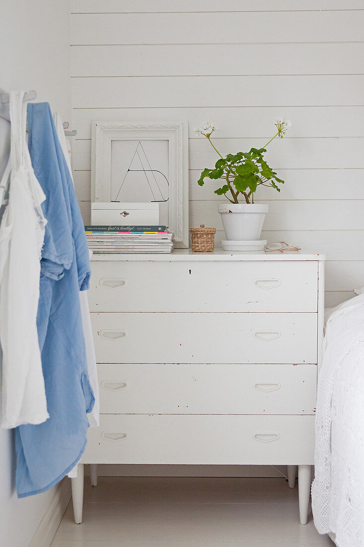 Old white chest of drawers used as bedside table