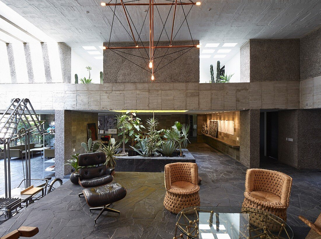 Designer furniture in open-plan interior of concrete house