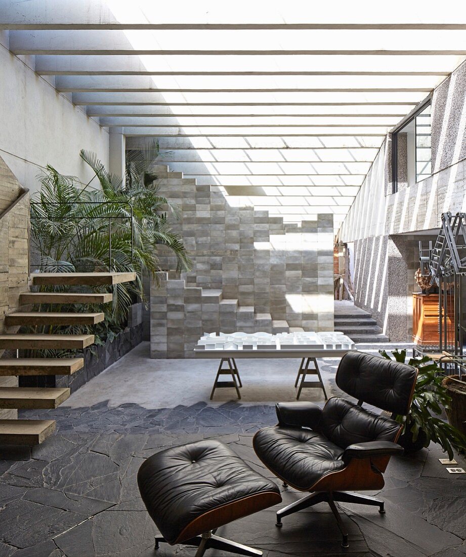 Designer furniture in open-plan interior of concrete house