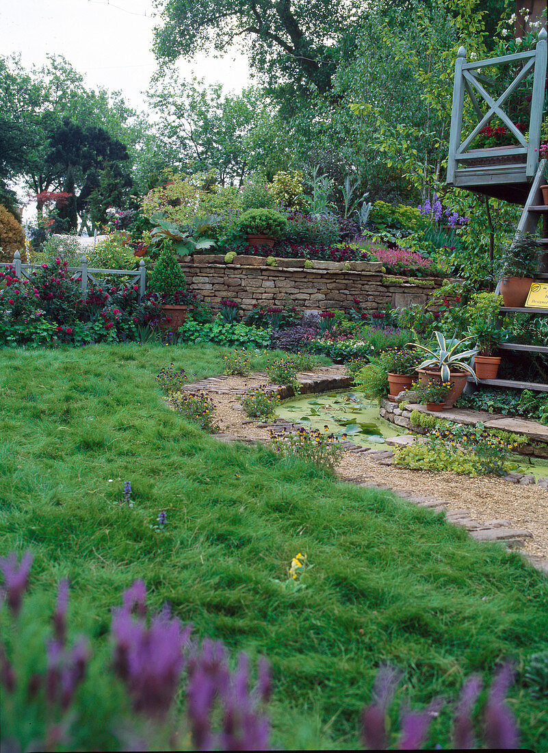 Hanging garden with dry stone wall, stream next to gravel path