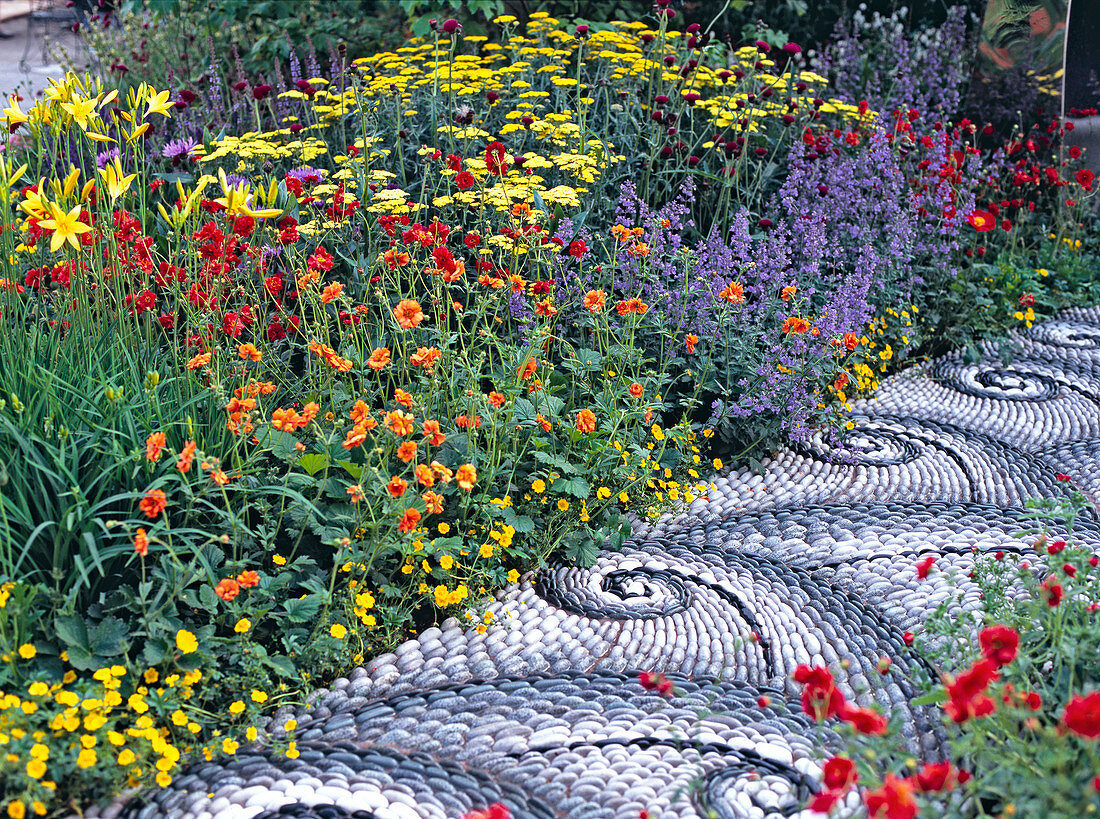 Mosaic path of Maggy Howarth through a colorful perennial border