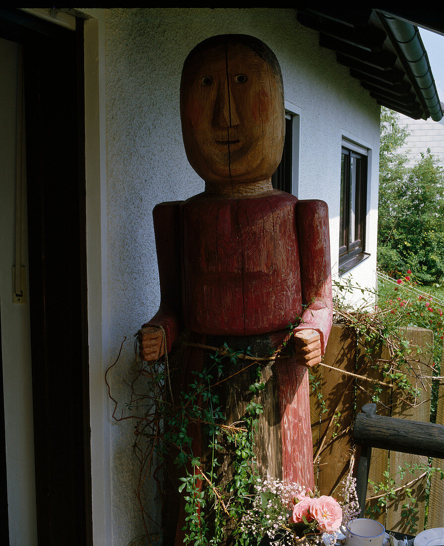 geschnitzte Holzpuppe am Hauseingang