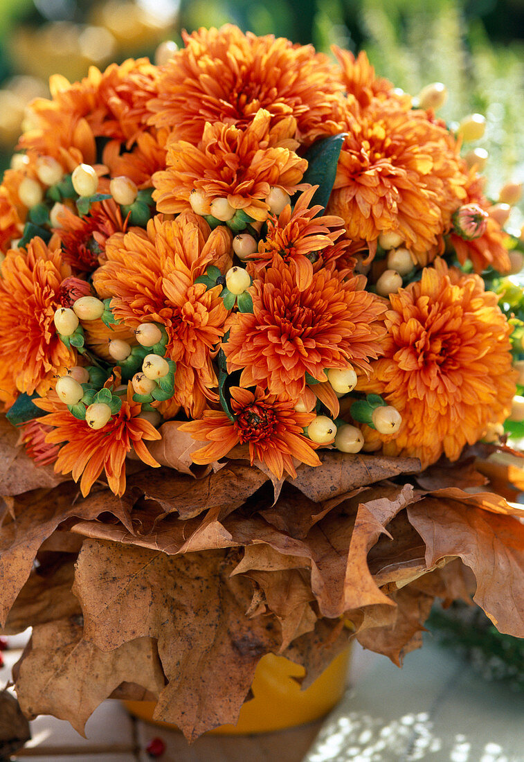 Bouquet with autumn chrysanthemums, fruits of Hypericum (St. John's shrub, autumn flowers), rose (roses) and rose hips