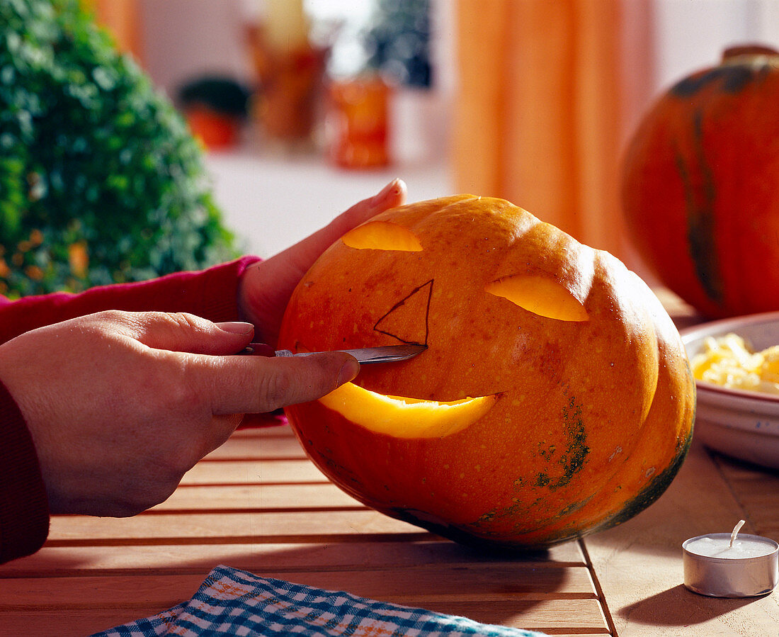 Homemade Halloween face - cutting out a face with a knife