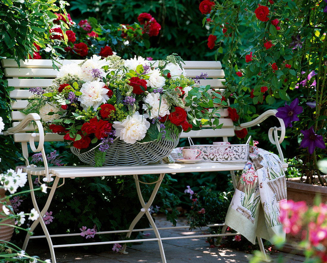 Garden bench with climbing rose 'Flammentanz', basket with arrangement