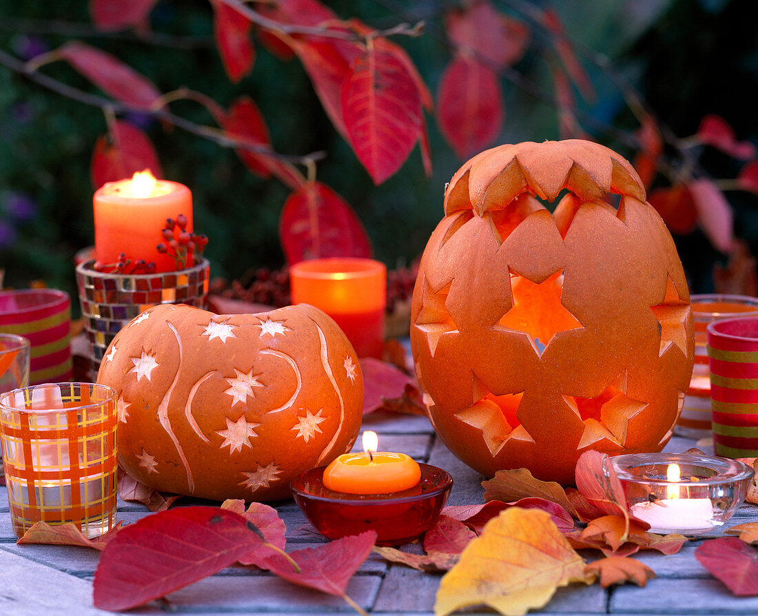 Cucurbita (pumpkin) eroded and decorated with star decoration, autumn leaves and candles