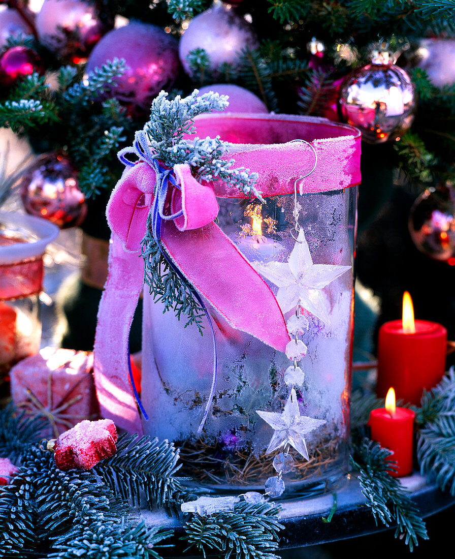 Glass lantern with bow, candles and hoarfrost