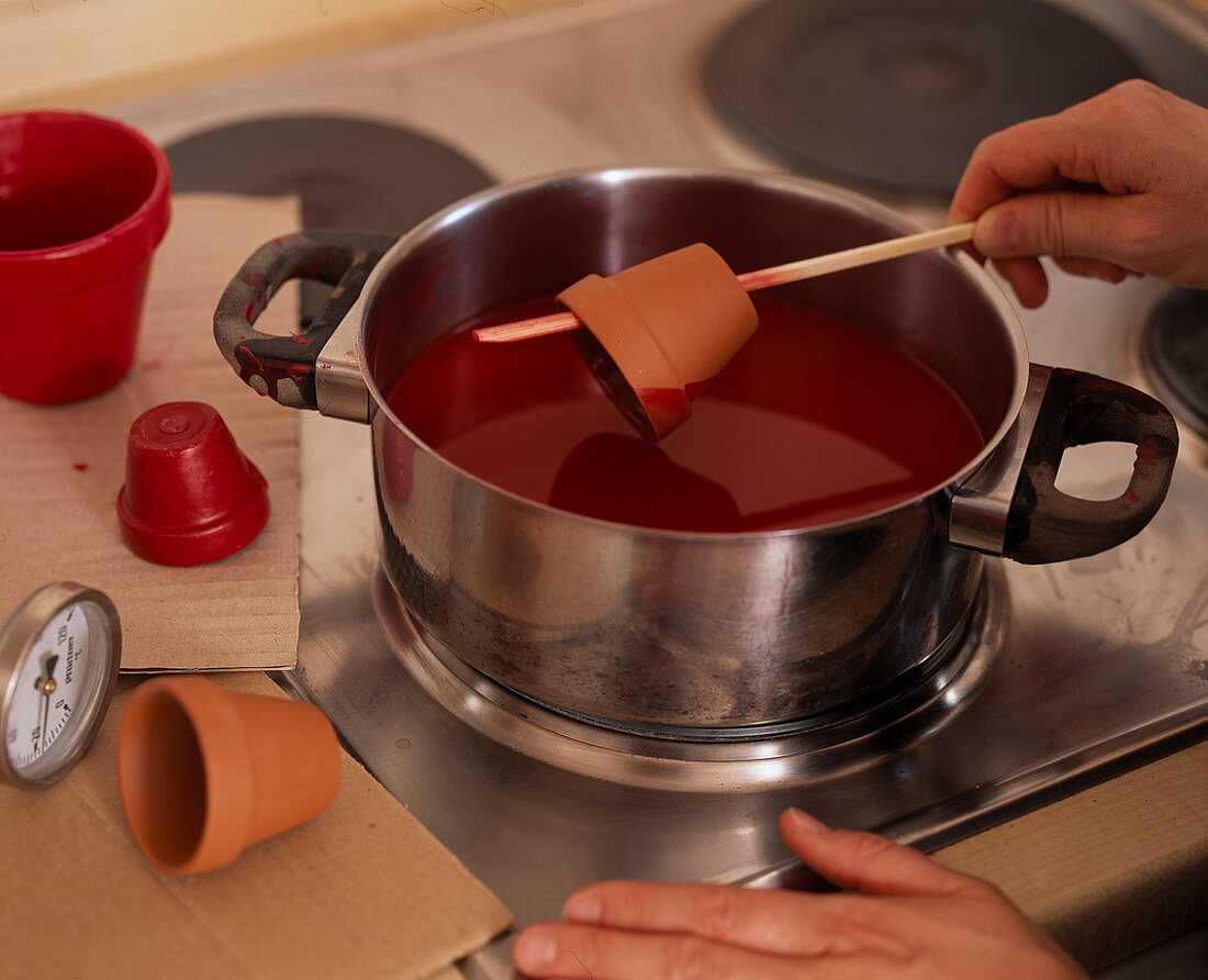 Red wax: Step (1/1). Dipping small clay pots in melted red wax