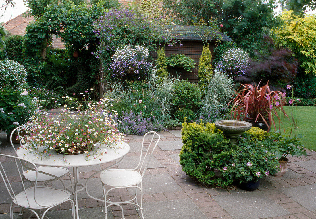 Terrace with seating area, potted plants and bird bath