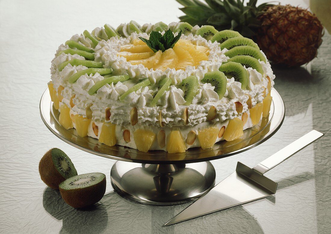 Kiwi fruit and pineapple cream gateau on cake stand