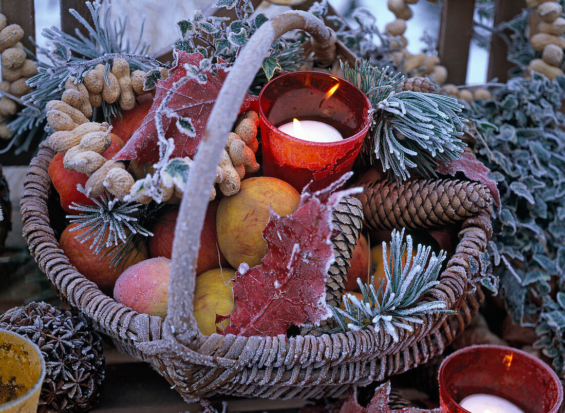 Filled wicker basket with hoarfrost with red glass wind lights