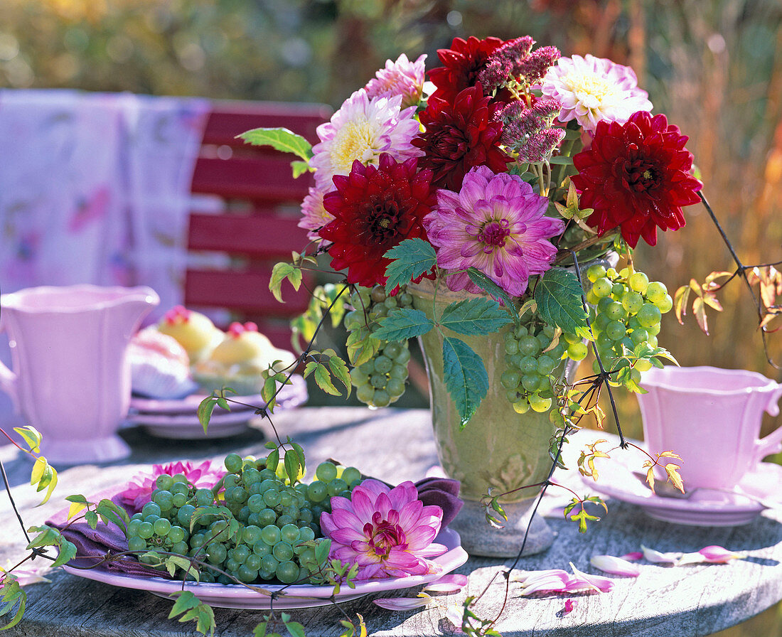 Autumn bouquet in green vase with dahlia in pink and maroon