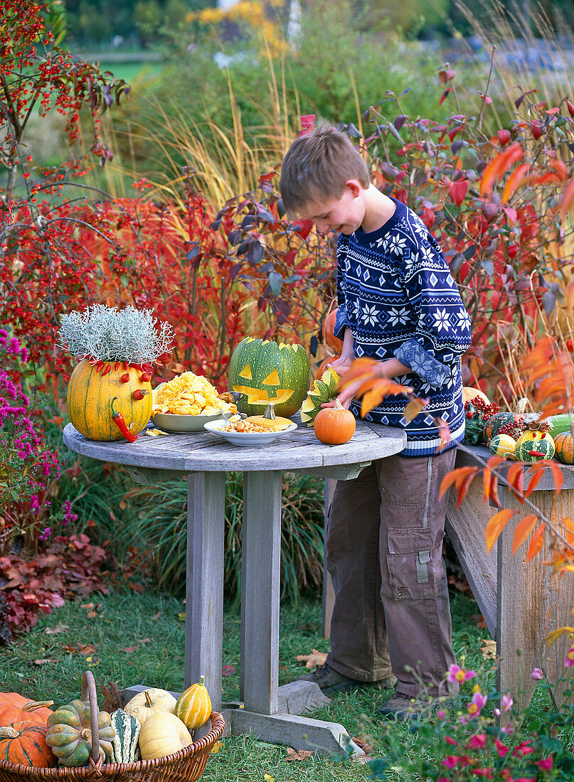Boy making crafts with cucurbita (ornamental squash, pumpkin)