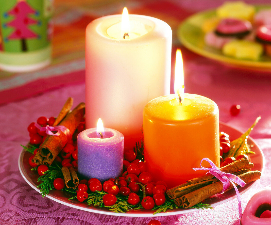 Plate with candles, cinnamon sticks, Ilex berries and false cypress