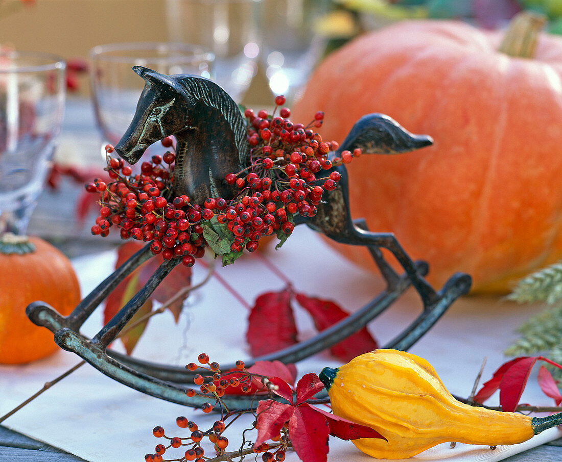 Metal rocking horse with wreath of pink (rose hip), Parthenocissus