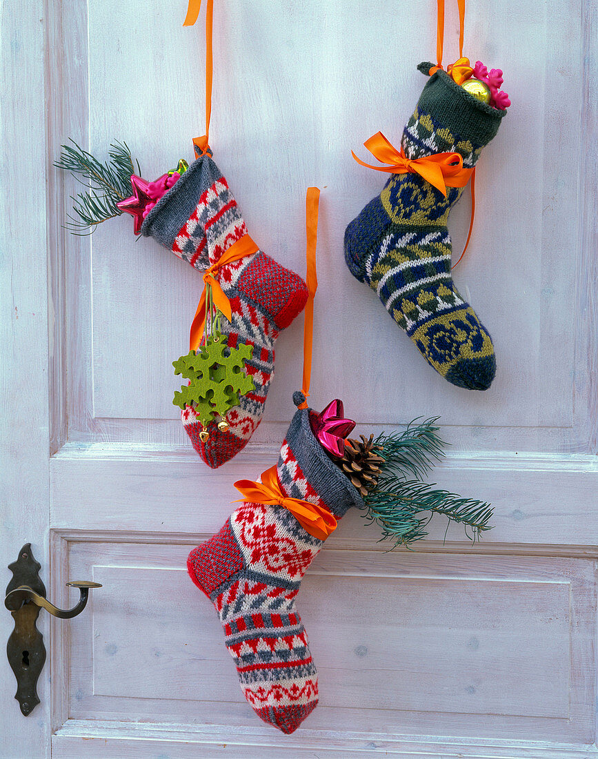Tür mit Nikolausdeko: bunte, gestrickte Socken mit Baumschmuck