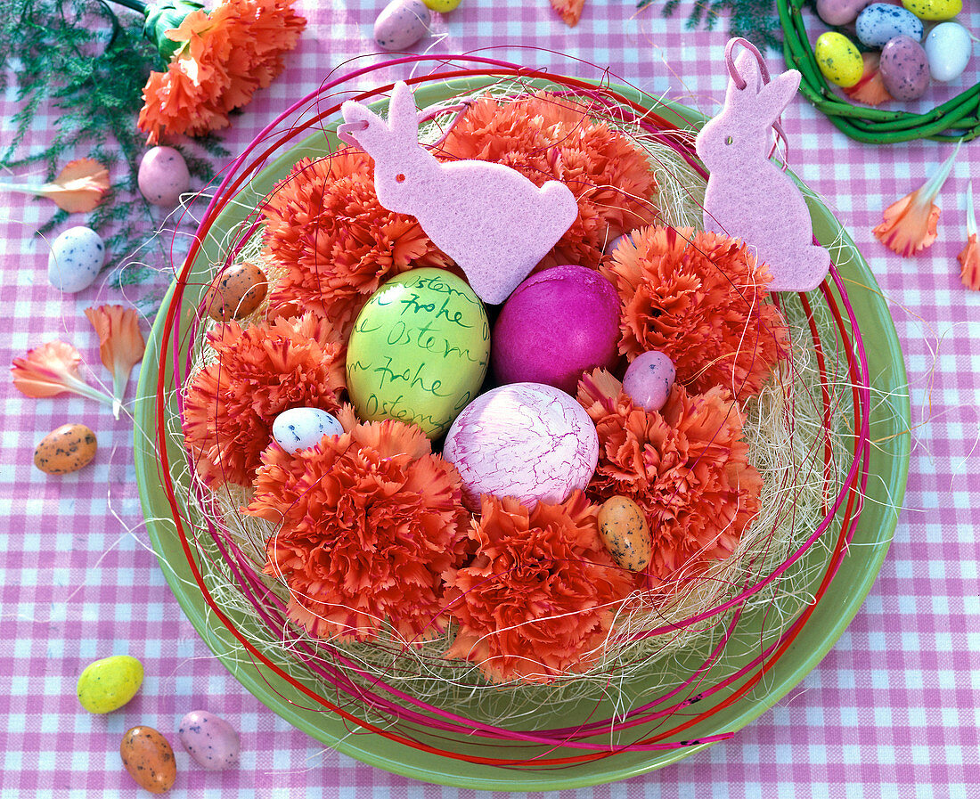 Easter basket with Dianthus flowers, Easter eggs, pink felt bunnies