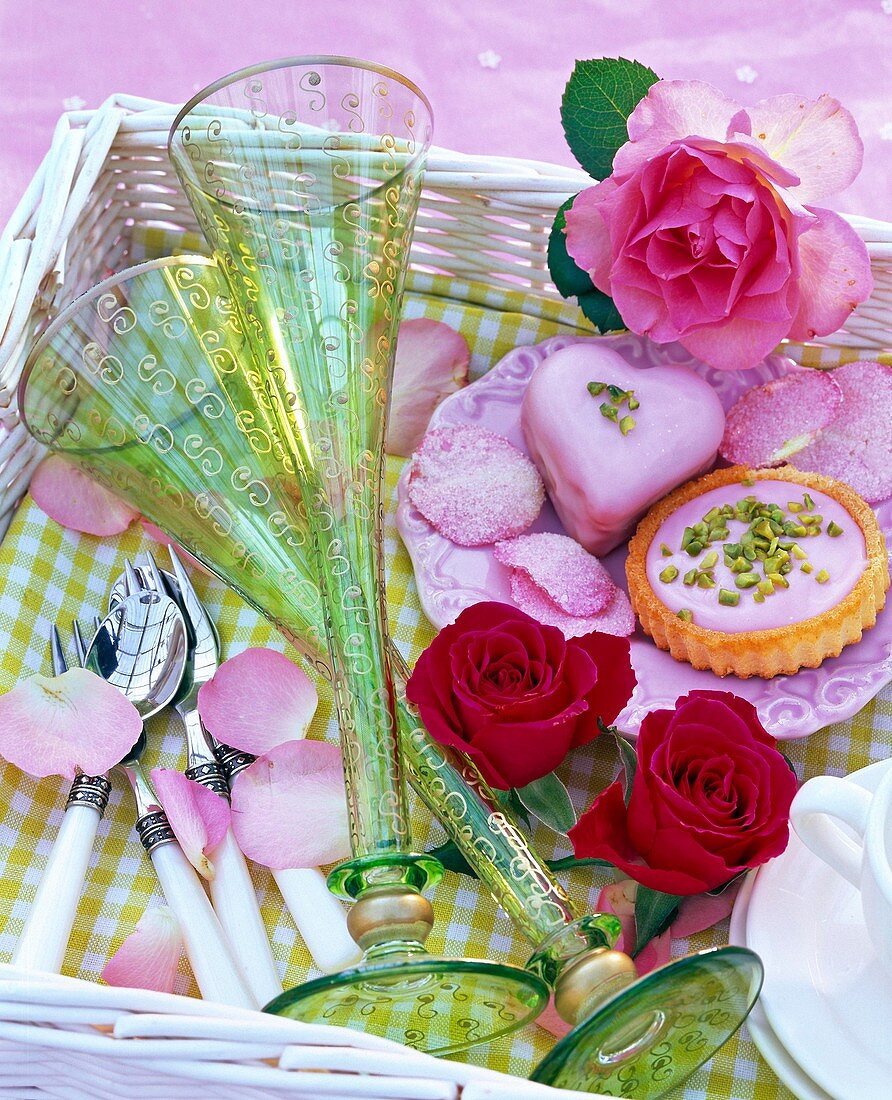 Still life with champagne flutes, pink flowers (rose, red and pink), petals