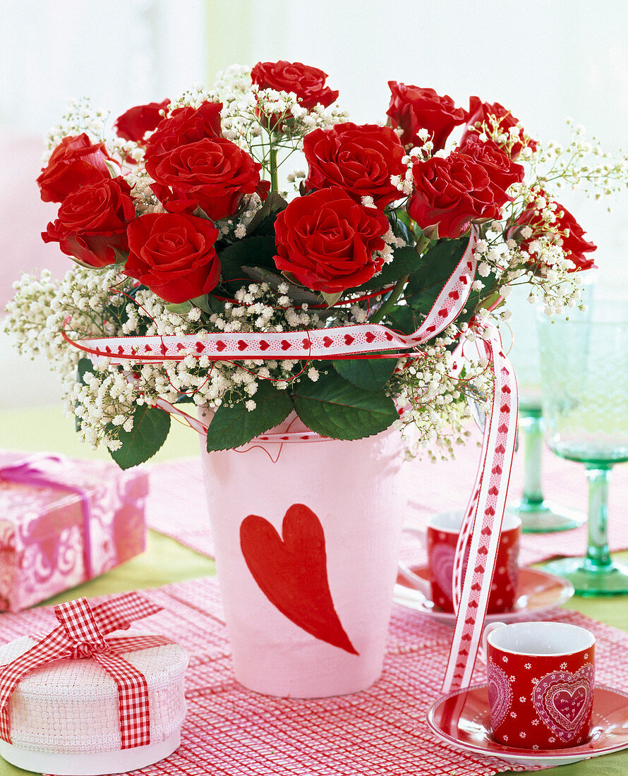 Bouquet of red pinks (roses), Gypsophila (baby's breath) in vase