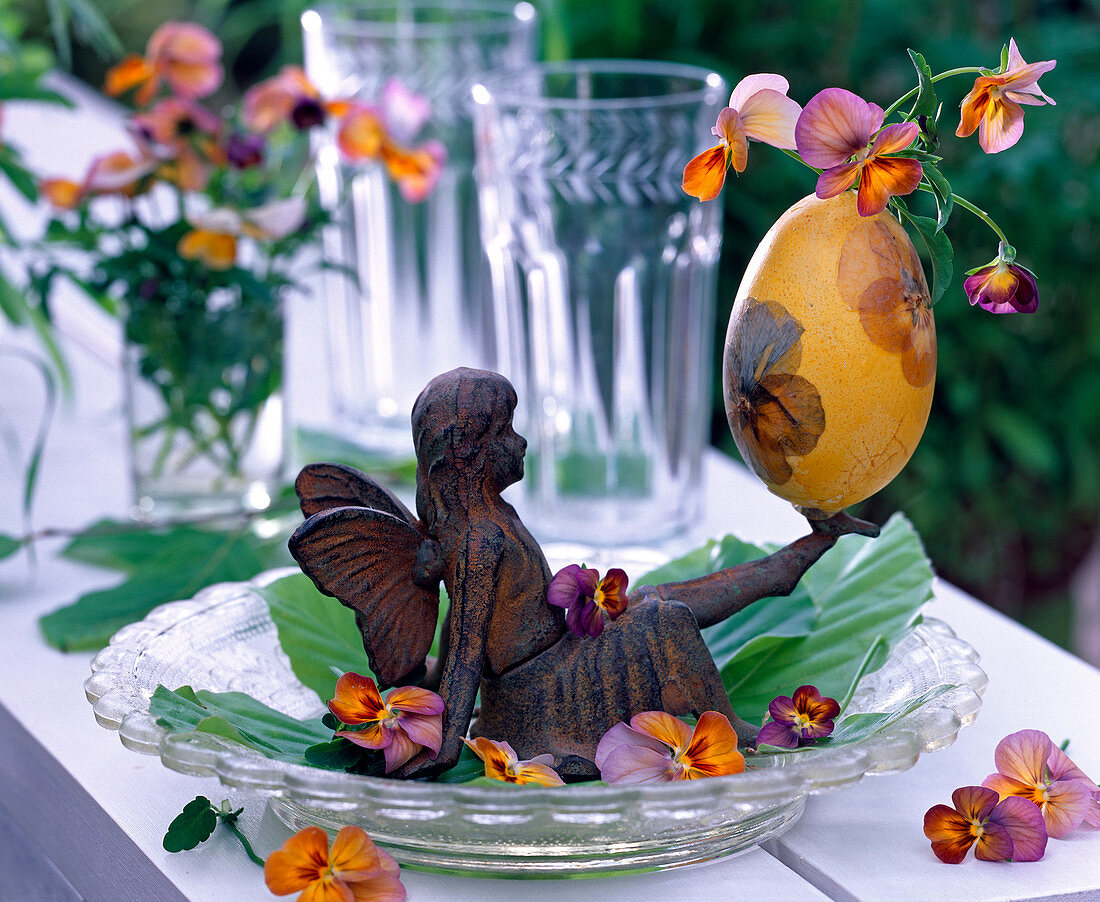 Angel balanced among flowers Easter egg vase with viola motif on foot