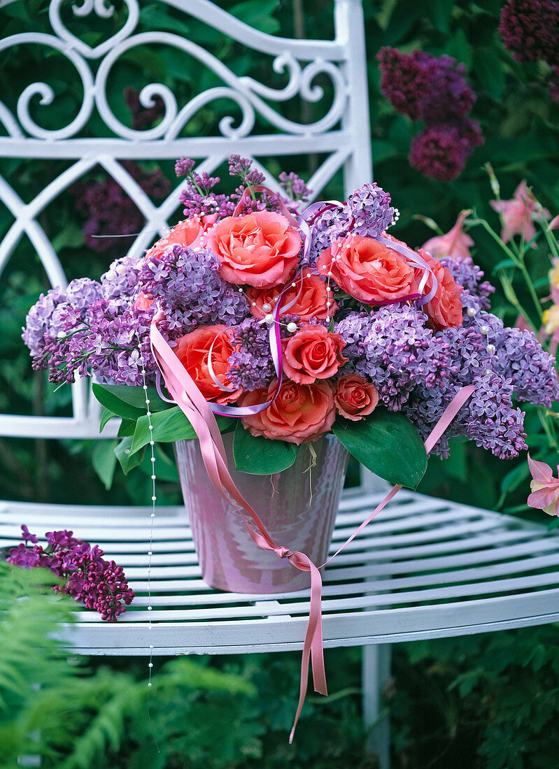 Bouquet of Syringa (lilac) and Rosa (roses) in pink vase, decorated