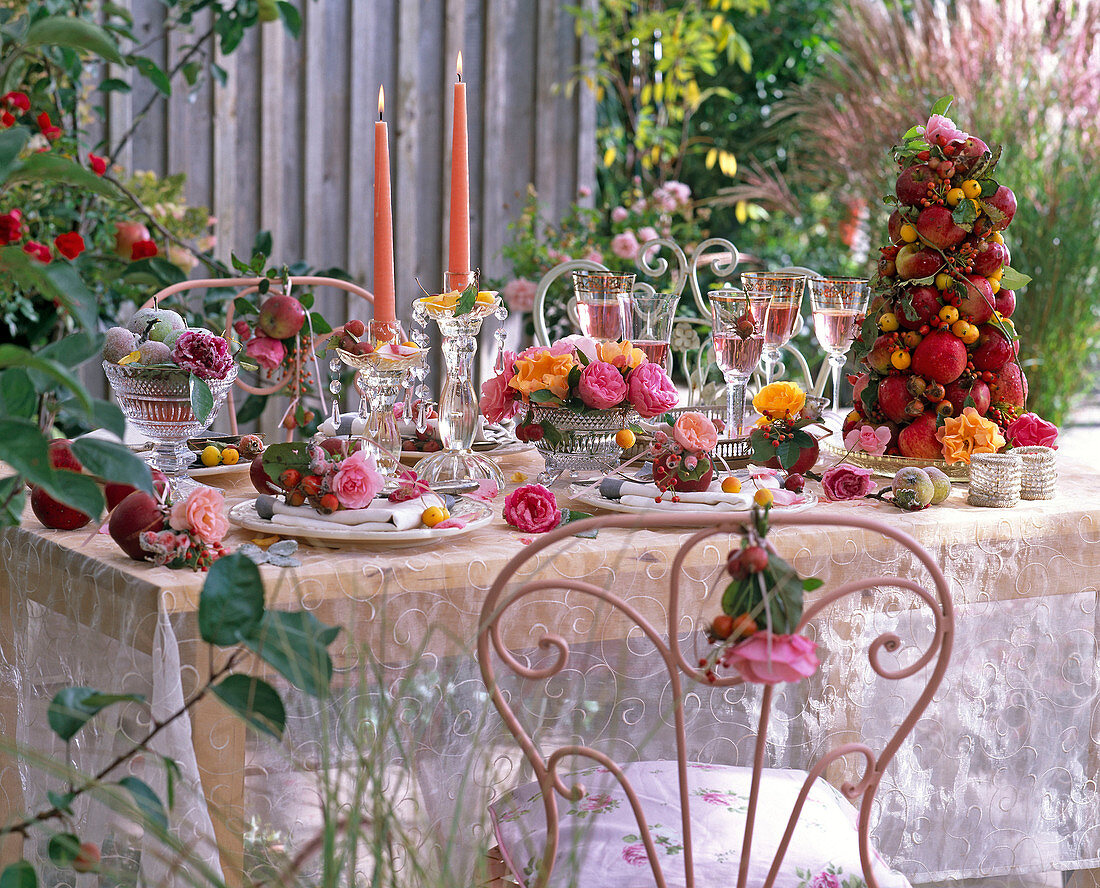 Tischdekoration mit Rosa (Rosen, Hagebutten) und Malus (Äpfeln, Zieräpfeln)