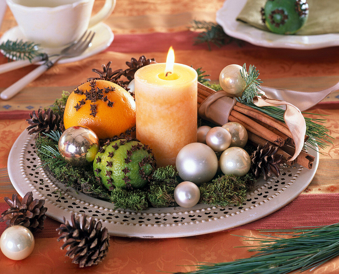 Citrus (Orange, Limette), weiße Kerze, Zimtstangen, silberne Baumkugeln