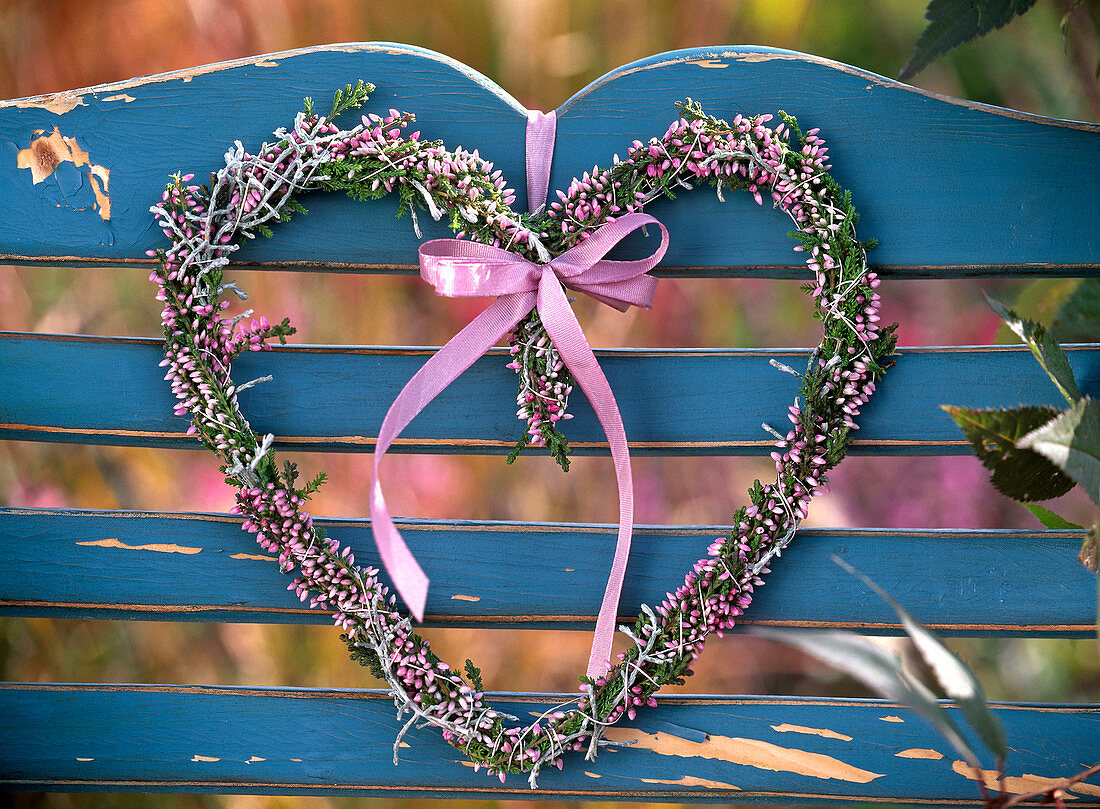 Heart of Calluna (broom heather) with pink ribbon tied to a blue backrest