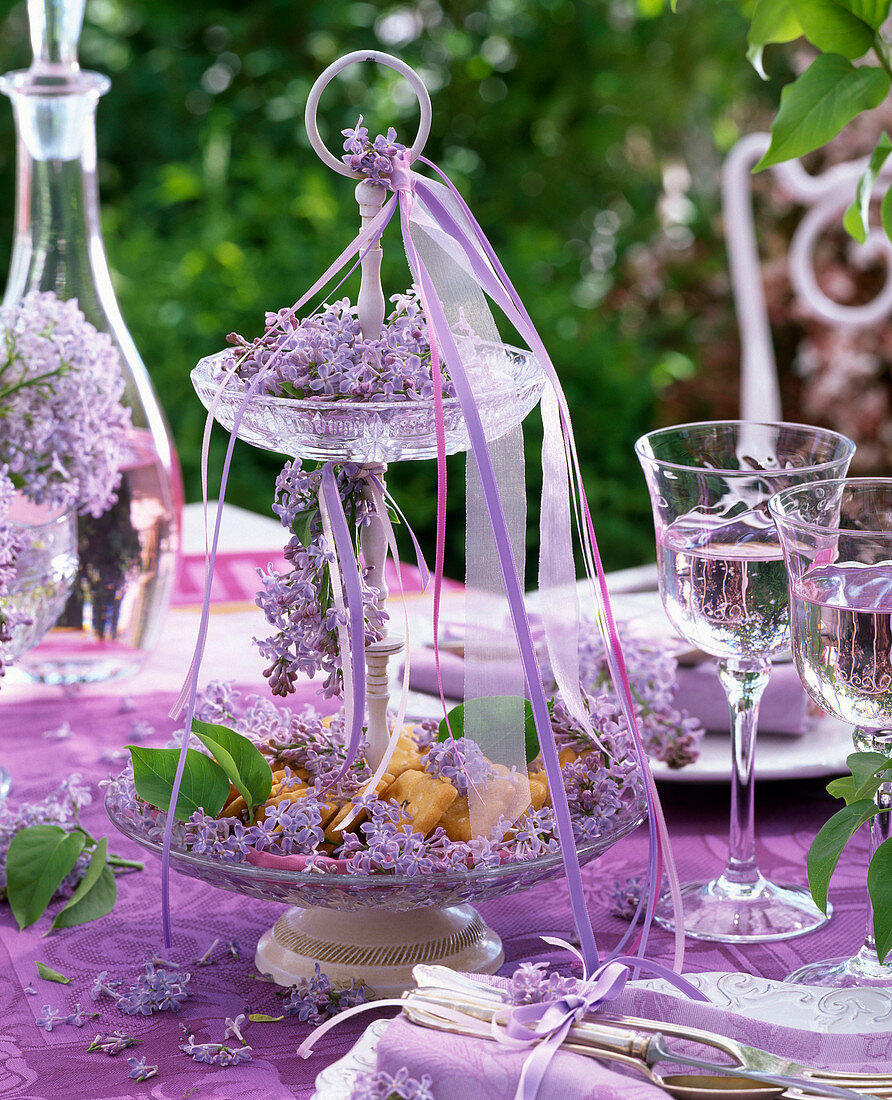 Table decoration with Syringa (lilac) and crystal glass