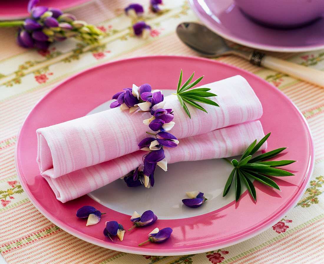 Napkin ring made of Lupinus flowers around striped napkin