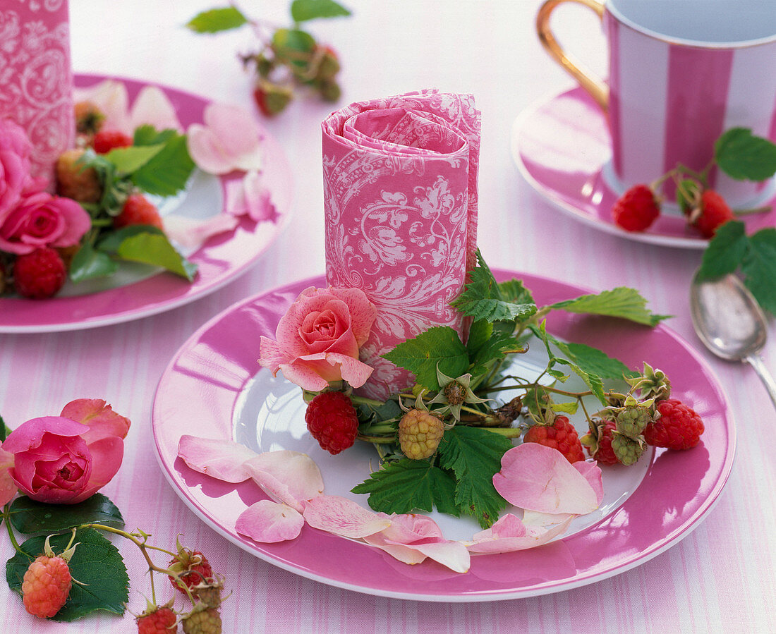 Pink (roses), Rubus (raspberries, tendril) around vertically placed napkin