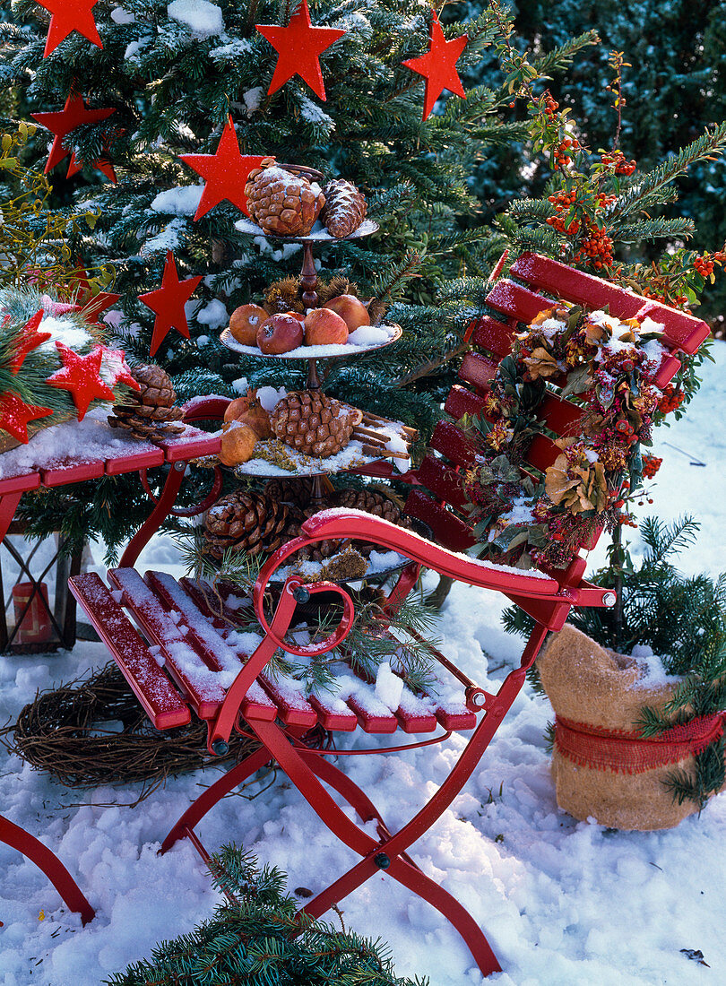 Roter Stuhl auf verschneiter Weihnachts-Terrasse